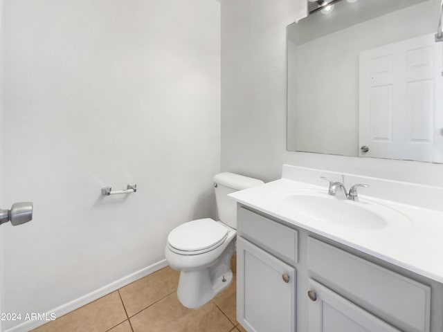 bathroom with toilet, vanity, and tile patterned floors