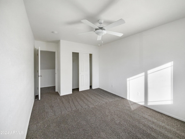 unfurnished bedroom featuring ceiling fan, a closet, and dark carpet