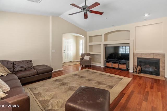 12712 W Milton Dr, Peoria, AZ 85383 - living area with built in shelves, a ceiling fan, arched walkways, wood finished floors, and lofted ceiling