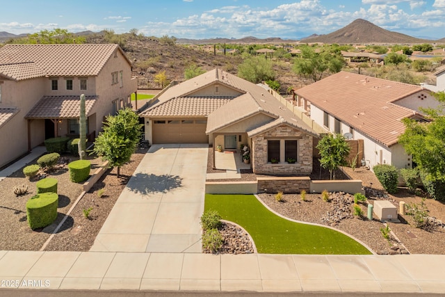 12712 W Milton Dr, Peoria, AZ 85383 - mediterranean / spanish-style home with concrete driveway, a mountain view, an attached garage, a residential view, and stucco siding