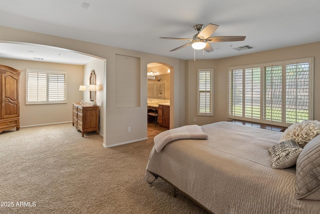 12712 W Milton Dr, Peoria, AZ 85383 - bedroom featuring arched walkways, baseboards, light colored carpet, a ceiling fan, and ensuite bath