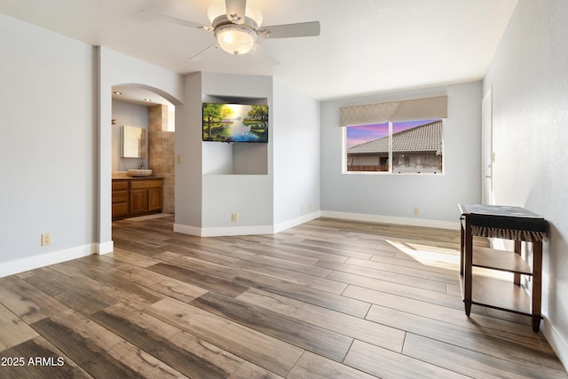 unfurnished living room featuring hardwood / wood-style floors and ceiling fan