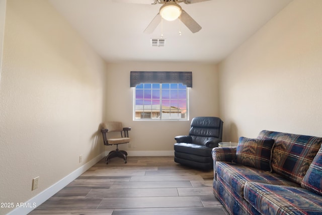 sitting room with ceiling fan and hardwood / wood-style floors