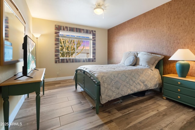 bedroom with ceiling fan and light hardwood / wood-style floors