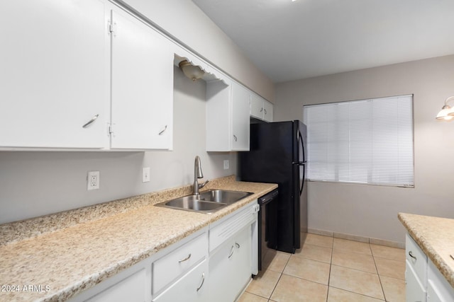 kitchen with sink, white cabinets, light tile patterned floors, and black dishwasher