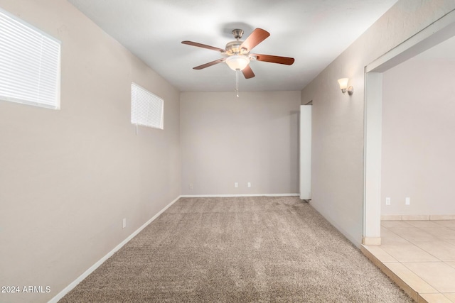 carpeted spare room with ceiling fan