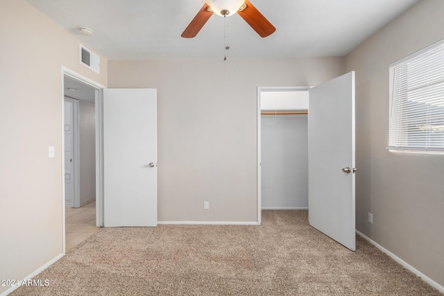 unfurnished bedroom with ceiling fan, a closet, and light carpet