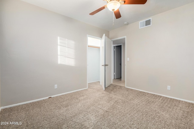 unfurnished bedroom with ceiling fan, a closet, and light colored carpet