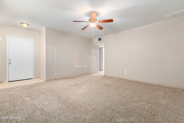 empty room featuring ceiling fan and light colored carpet