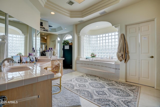 full bath with tile patterned flooring, visible vents, plenty of natural light, a raised ceiling, and ornate columns