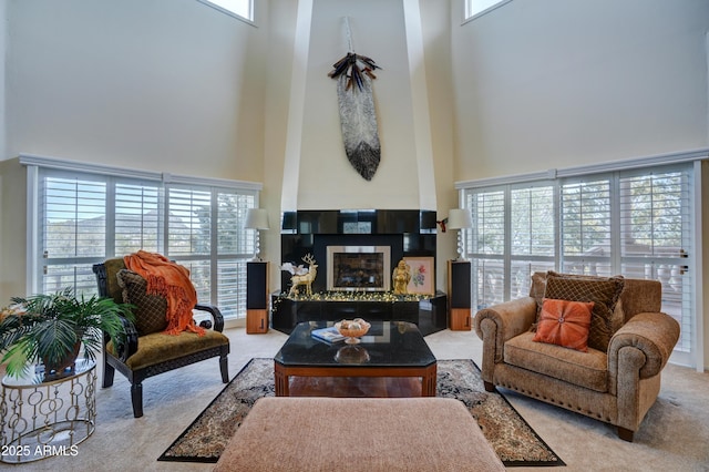 living room with a high ceiling, carpet flooring, and a fireplace