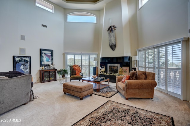 carpeted living area with visible vents and a fireplace