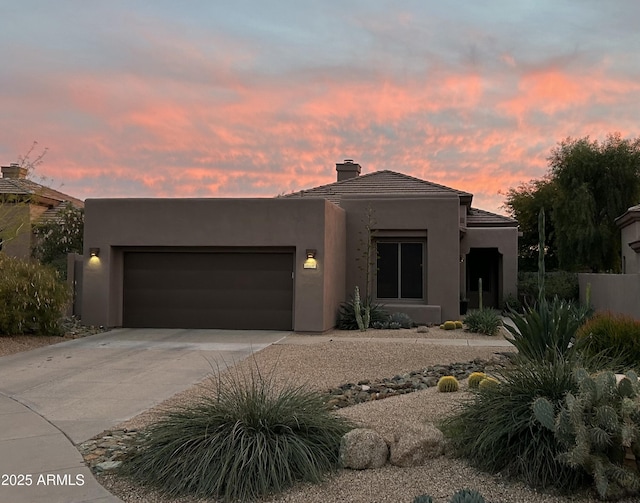 pueblo revival-style home featuring a garage