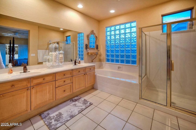 bathroom featuring tile patterned flooring, shower with separate bathtub, and vanity