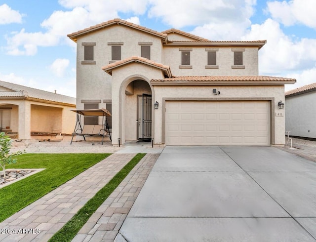 mediterranean / spanish-style house featuring a front lawn and a garage