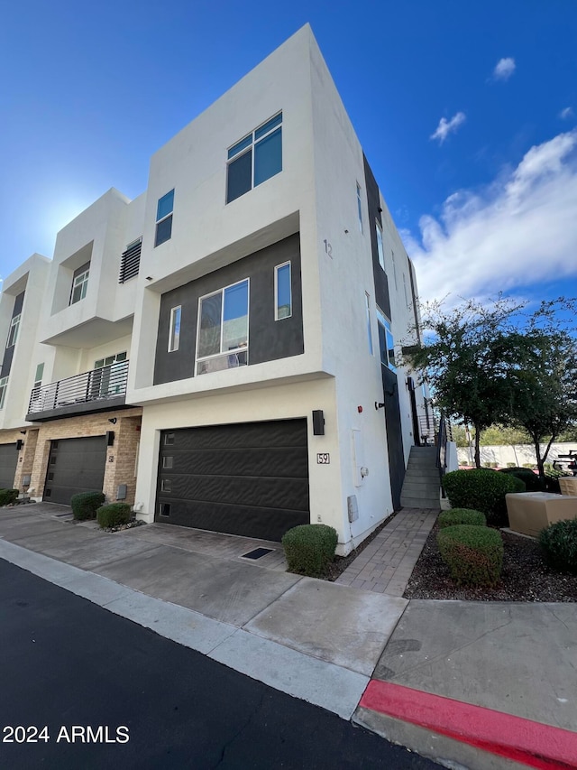 view of front of home featuring a balcony and a garage