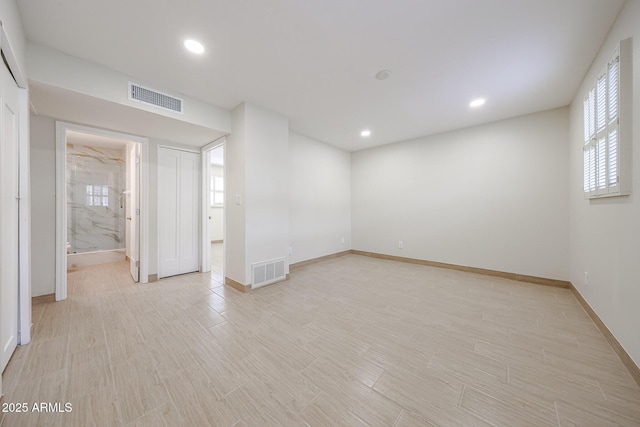 spare room with light wood-style floors, recessed lighting, visible vents, and baseboards