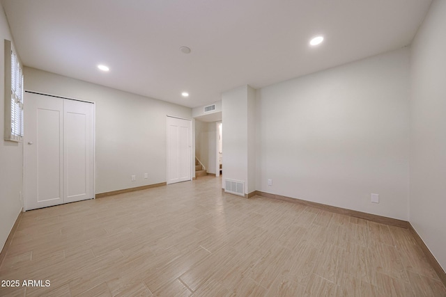 interior space with recessed lighting, visible vents, baseboards, stairs, and light wood finished floors