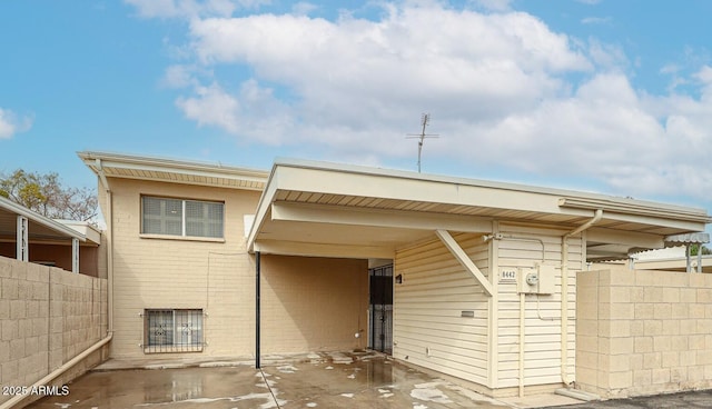 rear view of property with fence and brick siding