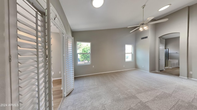 empty room with light carpet, ceiling fan, and lofted ceiling