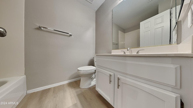 bathroom with toilet, vanity, and hardwood / wood-style flooring