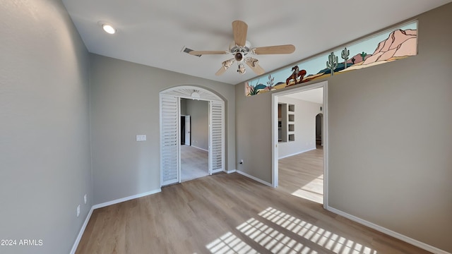 spare room with ceiling fan and light wood-type flooring