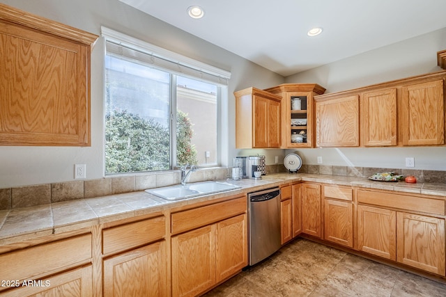 kitchen with tile countertops, dishwasher, and sink