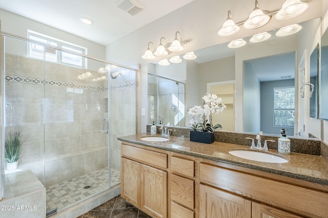 bathroom with tile patterned flooring, vanity, and walk in shower