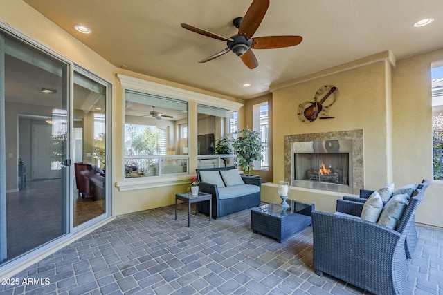 view of patio / terrace featuring a fireplace and ceiling fan