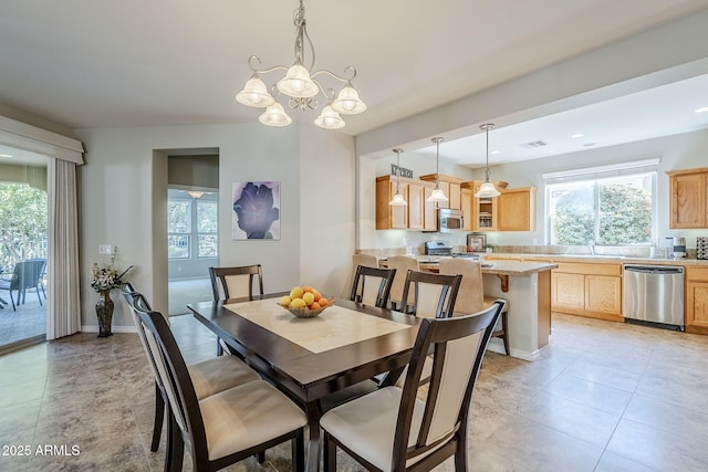 dining space with plenty of natural light, light tile patterned floors, and a chandelier