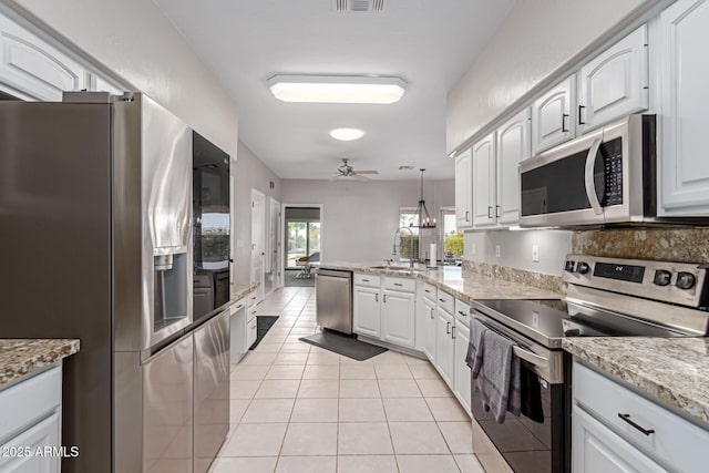 2714 N 63rd St, Mesa, AZ 85215 - kitchen with white cabinetry, appliances with stainless steel finishes, decorative light fixtures, and light tile patterned floors