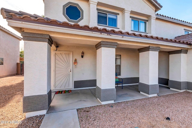 10847 E Forge Cir, Mesa, AZ 85208 - view of exterior entry with stucco siding, a tiled roof, and a patio