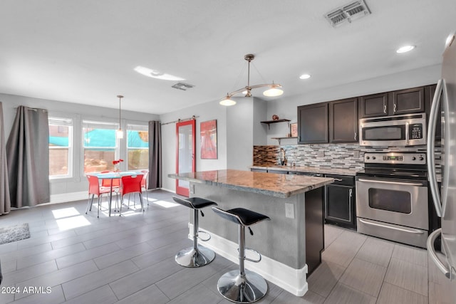 10847 E Forge Cir, Mesa, AZ 85208 - kitchen with appliances with stainless steel finishes, backsplash, light stone countertops, a sink, and baseboards