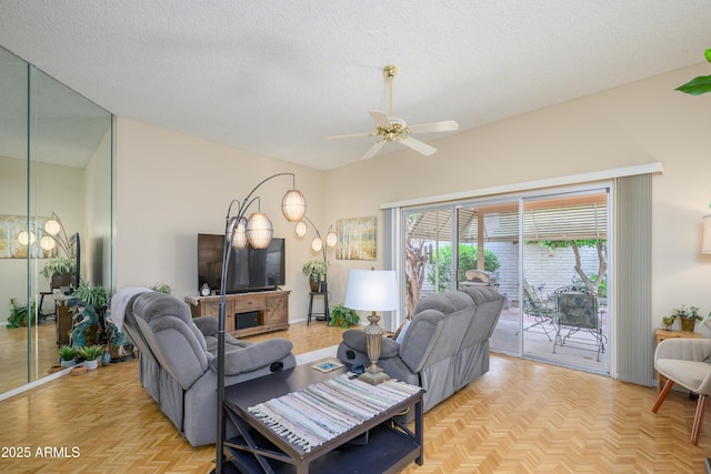 living room featuring ceiling fan, baseboards, and a textured ceiling