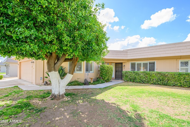 view of front of home featuring a front lawn, concrete driveway, and a garage