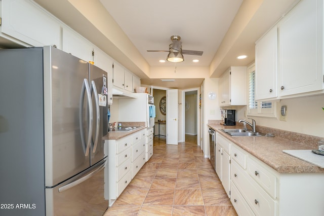 kitchen with white cabinets, appliances with stainless steel finishes, ceiling fan, and a sink