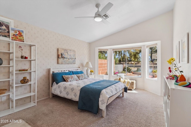 bedroom with a ceiling fan, light carpet, vaulted ceiling, and wallpapered walls