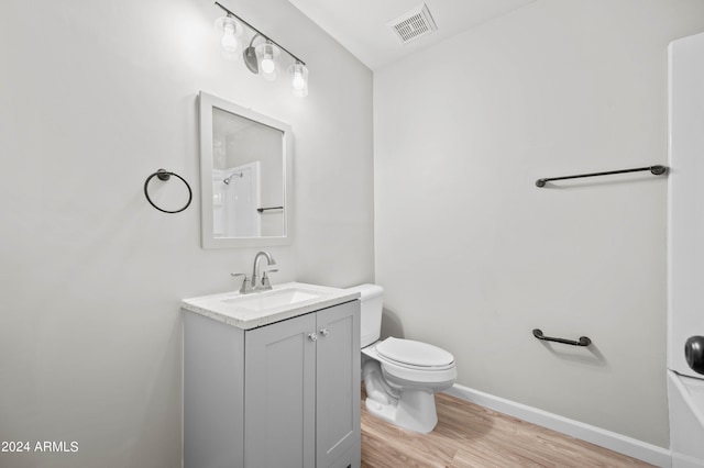 bathroom featuring vanity, toilet, hardwood / wood-style floors, and a tub