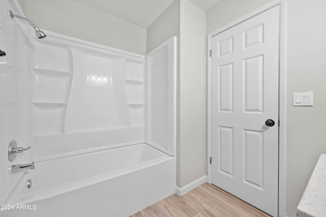 bathroom with wood-type flooring and bathing tub / shower combination