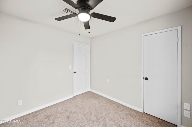 carpeted spare room featuring ceiling fan