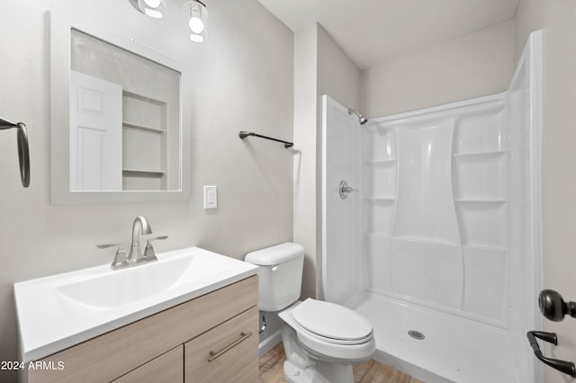 bathroom with walk in shower, toilet, wood-type flooring, and vanity