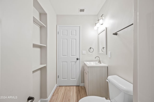 bathroom featuring vanity, toilet, and hardwood / wood-style flooring