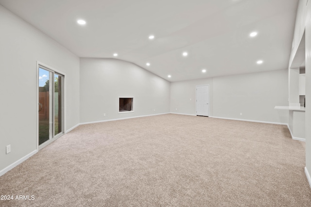 carpeted empty room featuring lofted ceiling