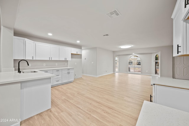 kitchen featuring light wood-type flooring, sink, and white cabinets