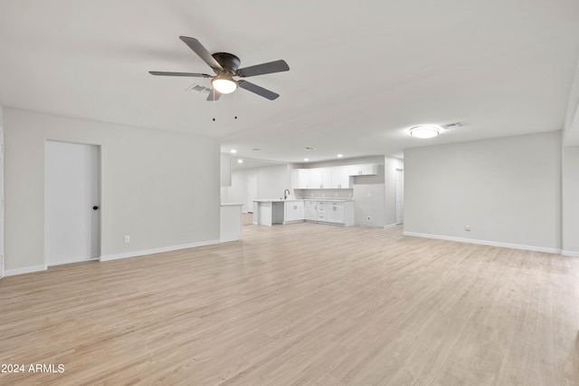 unfurnished living room featuring ceiling fan and light hardwood / wood-style floors