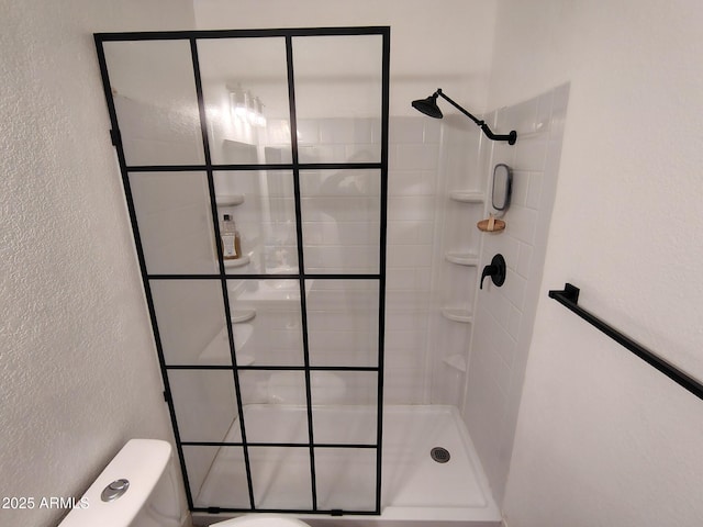 bathroom with toilet and tiled shower