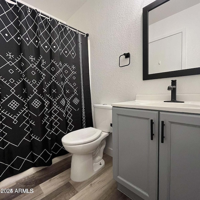 bathroom featuring a shower with curtain, vanity, hardwood / wood-style floors, and toilet