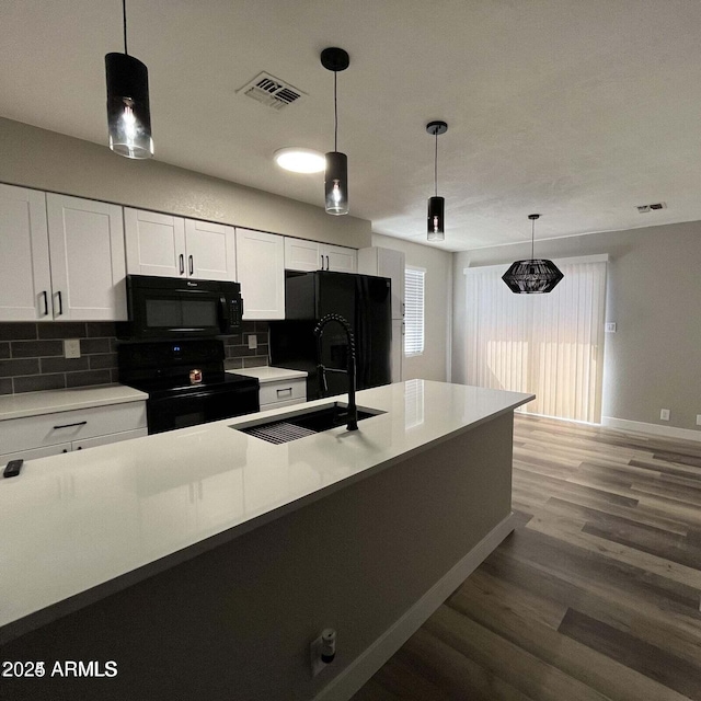 kitchen with sink, black appliances, white cabinets, pendant lighting, and backsplash