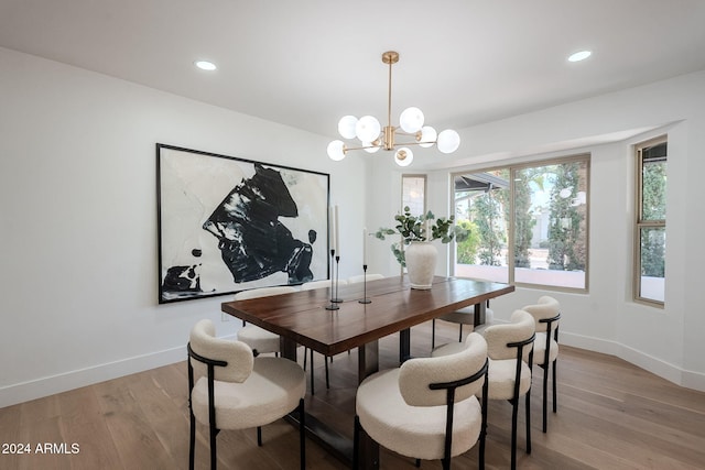 dining area with a notable chandelier and light hardwood / wood-style flooring