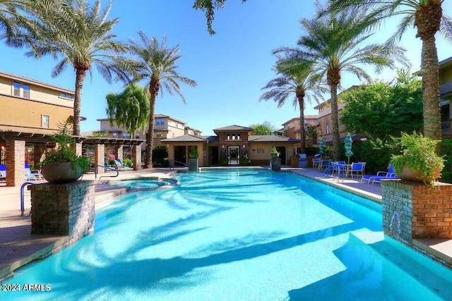 view of swimming pool featuring a hot tub and a patio area